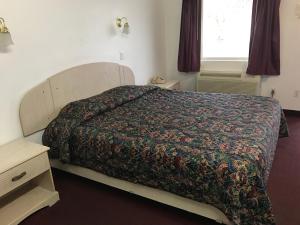ein Schlafzimmer mit einem Bett mit einer farbenfrohen Tagesdecke in der Unterkunft Mayfair Motel in Cross Keys