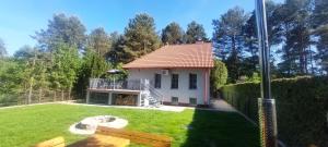 a small white house in a yard at Apartament AURA - Cichy Zakątek - Kujanki in Kujanki