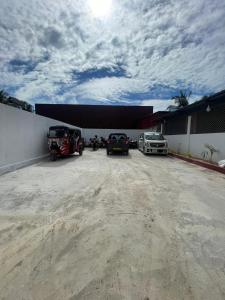 a parking lot with cars parked in front of a building at Gulf Villa in Kattankudi +1 photo
