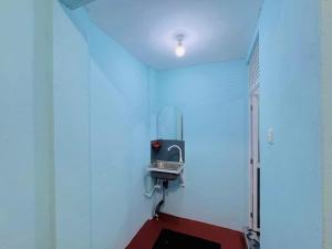 a bathroom with a sink in a white wall at Gulf Villa in Kattankudi