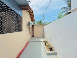 a hallway of a white building with potted plants at Gulf Villa in Kattankudi