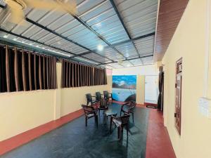 a room with chairs and a table in it at Gulf Villa in Kattankudi