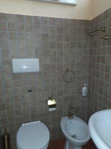 a bathroom with a toilet and a sink at I QuattroGioielli in SantʼAngelo le Fratte +7 photos