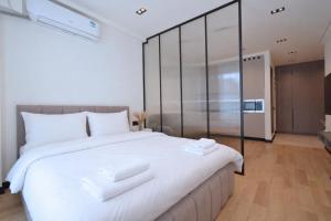 a bedroom with a large white bed with towels on it at Chic city apartment I By Domel Yerevan in Yerevan