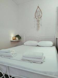 a white bed with white towels on top of it at Cucuvaya Rithy in Áyios Andónios