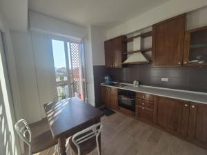 a kitchen with wooden cabinets and a table and a window at Affittacamere Le Fontane in Altopascio