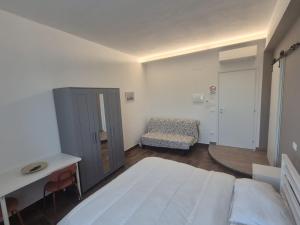a white bedroom with a bed and a chair at Affittacamere Le Fontane in Altopascio