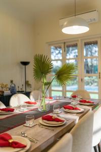a long wooden table with red napkins and plates on it at Villa Kefi in Assagao