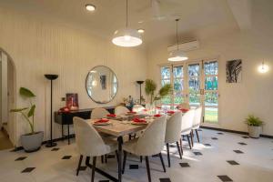a dining room with a table and chairs and a mirror at Villa Kefi in Assagao +18 photos