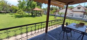 a balcony with a table and a gazebo at Kanela House ,Cozy Cottage with Large Garden & BBQ in Nea Kallikrateia