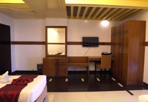 a bedroom with a desk and a bed and a television at The Sea Princess Hotel in Cox's Bazar
