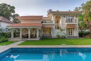 a house with a swimming pool in front of it at Villa Kefi in Assagao