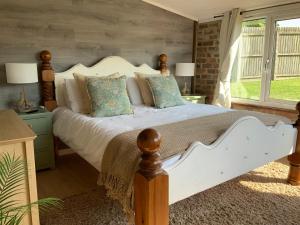 a bedroom with a large white bed with pillows at fairfeilds cottage Frog Trotters Bottom in Hartpury