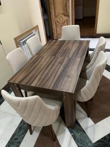a wooden dining room table with white chairs at Rahat Hotel in Ganja +32 photos