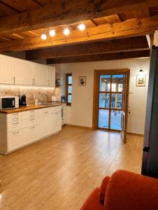 a kitchen with white cabinets and a wooden ceiling at Mézes-Kuckó in Tihany