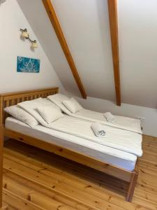 a bed in a room with white sheets and pillows at Mézes-Kuckó in Tihany
