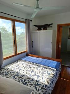 a bedroom with a bed in a room with windows at Luna Studio in Apia