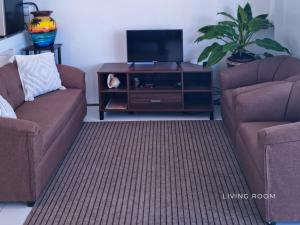 a living room with two chairs and a flat screen tv at The Clifftop Home in Esperanza