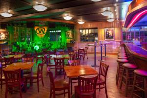 a restaurant with wooden tables and chairs and green lighting at The Wort Hotel in Jackson