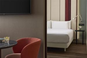 a room with a bed and a table and a chair at NH Barcelona Diagonal Poblenou in Barcelona