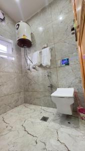 a bathroom with a toilet and a light on the wall at Pahadon Ka Ghar in Sonāmarg