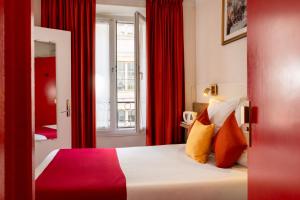 a hotel room with a bed with red curtains at Hôtel Saint Roch in Paris