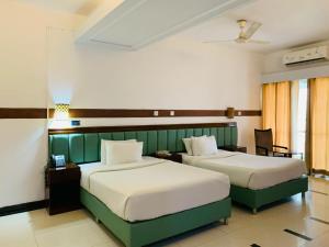 two beds in a hotel room with two beds at The Sea Princess Hotel in Cox's Bazar +23 photos