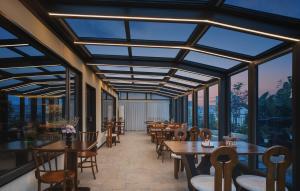 a restaurant with tables and chairs and large windows at Chengdu Yunduo 云朵Hotel in Chengdu