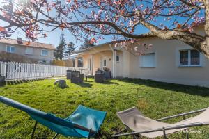 a yard with two chairs and a tree at Le balcon de Compostelle in Espaly-Saint-Marcel