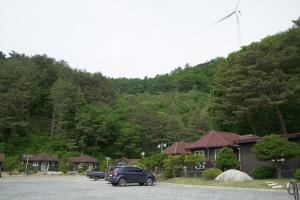 a car parked in a parking lot in front of a mountain at Yeongwol Jangsan Condo in Yeongwol