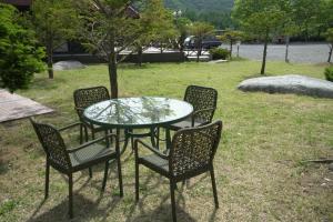 a table and four chairs and a table and a table and chairs at Yeongwol Jangsan Condo in Yeongwol