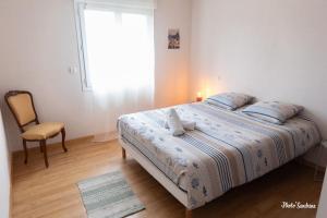 a bedroom with a bed with a chair and a window at Le balcon de Compostelle in Espaly-Saint-Marcel