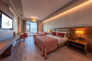 a hotel room with a bed and a large window at Grand Asya Hotel in Bandırma
