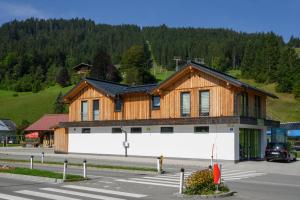 a large wooden building on the side of a road at Ferienwohnung Klugis in Gosau