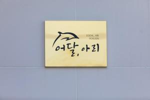 a sign on a wall with a picture of a dolphin at Donghae aeodalari pension in Donghae
