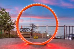 an orange circular mirror with lights on a balcony at Donghae aeodalari pension in Donghae