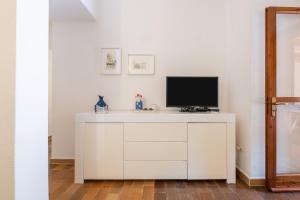 a white cabinet with a television on top of it at Villetta Pineta in Santa Margherita di Pula