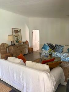 a living room with a white couch and a table at Bayerley in Plettenberg Bay
