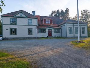 a large white house with a red door at Skärvsta gamla skola in Sollefteå