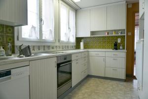 a kitchen with white cabinets and a sink at Gemütliches Appartement im Emmental - Sumiswald in Sumiswald