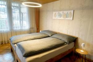 a bedroom with a bed with pillows on it at Gemütliches Appartement im Emmental - Sumiswald in Sumiswald