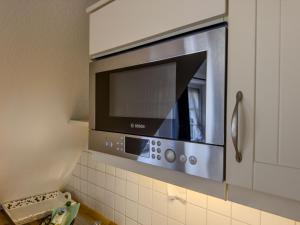 a microwave oven hanging from a wall in a kitchen at Mühlenhof, Keitum auf Sylt in Sylt +131 photos