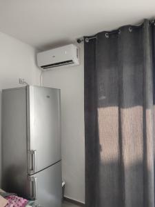 a kitchen with a refrigerator and a curtain at Dinos Apartments in Ulcinj