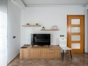 a living room with a tv and a table and a chair at Villa Victor in Riumar
