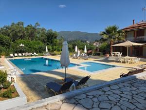 a swimming pool with two chairs and an umbrella at Corfu Paloma Apartments in Ipsos