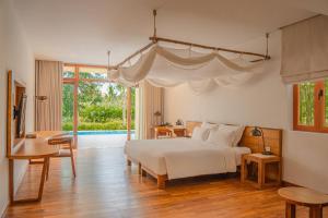 a bedroom with a bed with a white canopy at Ana Mandara Cam Ranh in Cam Ranh