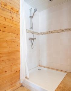 a bathroom with a shower with wooden walls at Chalet des Épicéas in Chorges +1 photo