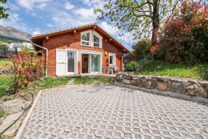 a small wooden house with a stone driveway at Chalet des Épicéas in Chorges