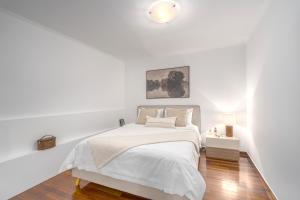 a white bedroom with a bed and a lamp at Riviera by Urban Luxy in Athens