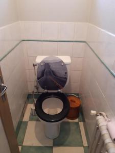a bathroom with a toilet with a black seat at chambres nature in La Celle-sous-Gouzon